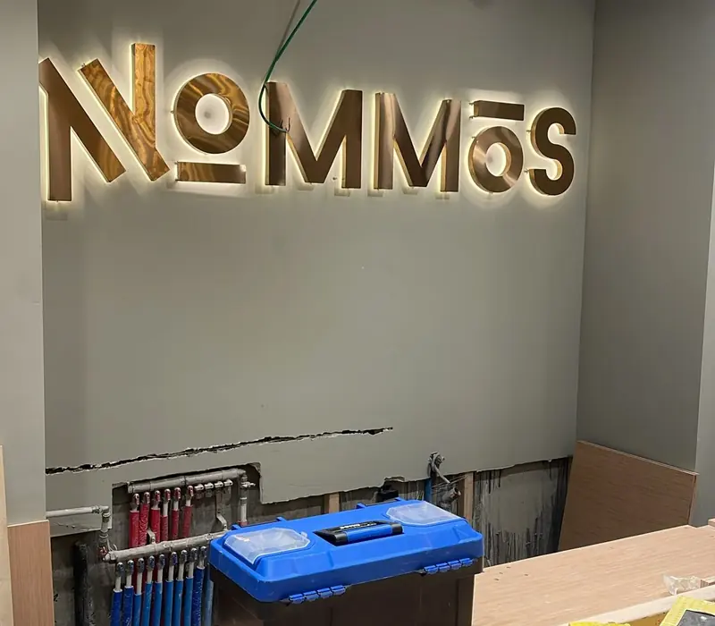 Lettres dorées rétroéclairées Nommos sur un mur intérieur